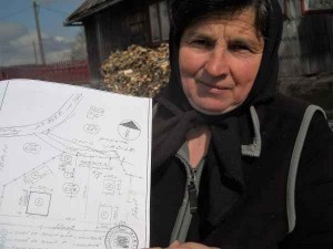 Maria Mariş demonstrează cum, peste noapte, Primăria Mărişel a trasat o stradă în curtea gospodăriei sale